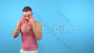 穿着粉红色衬衫的英<strong>俊男</strong>子正在与粉红色哑铃进行健身。